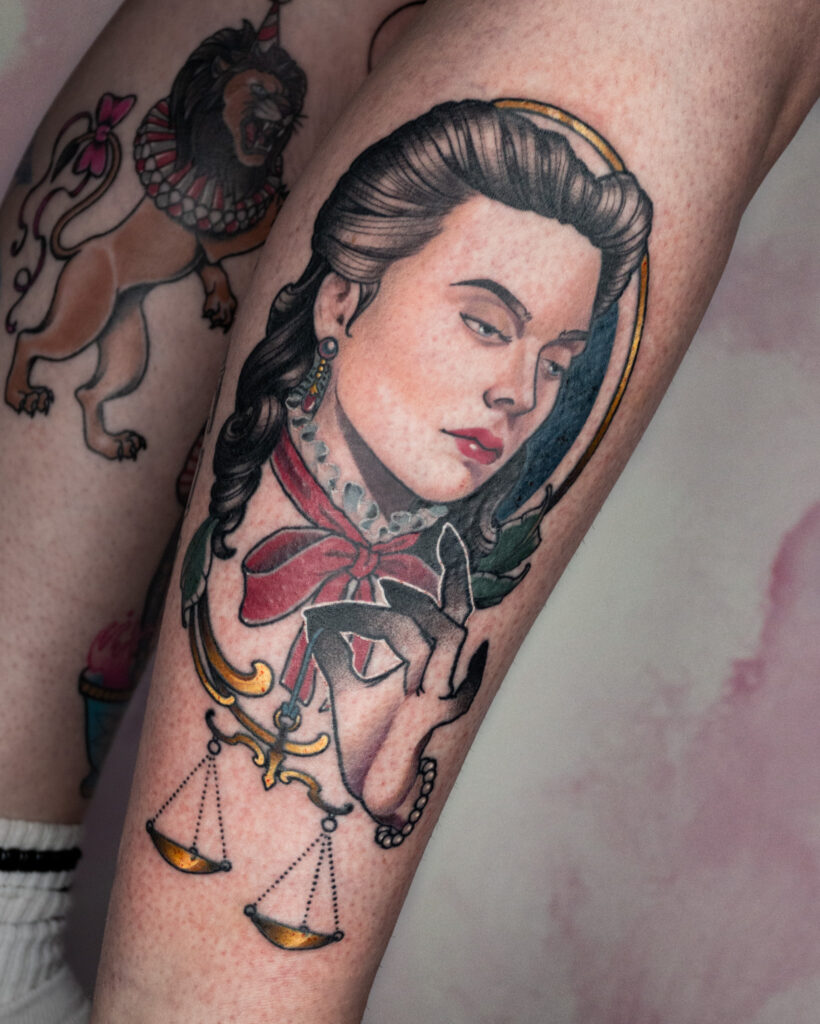 Neotraditional tattoo of a woman holding a scale, symbolizing justice and balance, by Alex Lukasiewicz