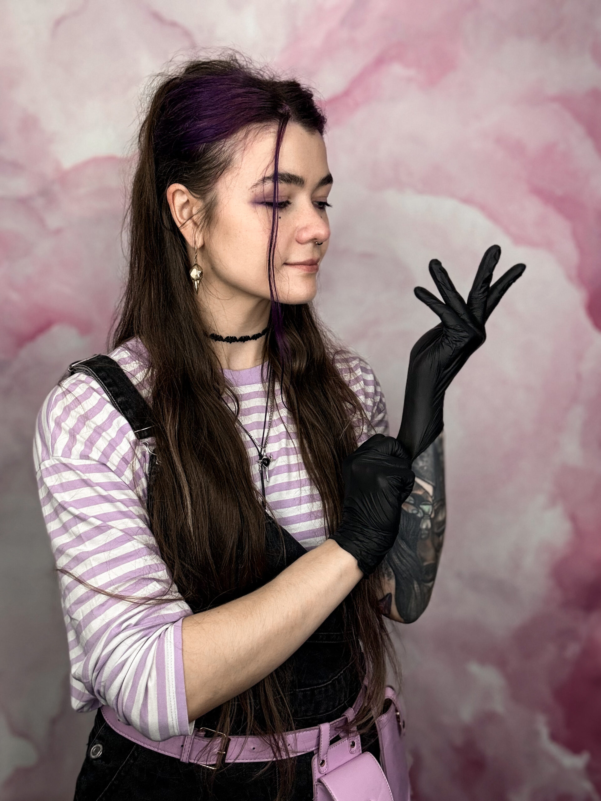 Alex from Meow Ink putting black nitryle gloves on hands in her private studio in Den Haag