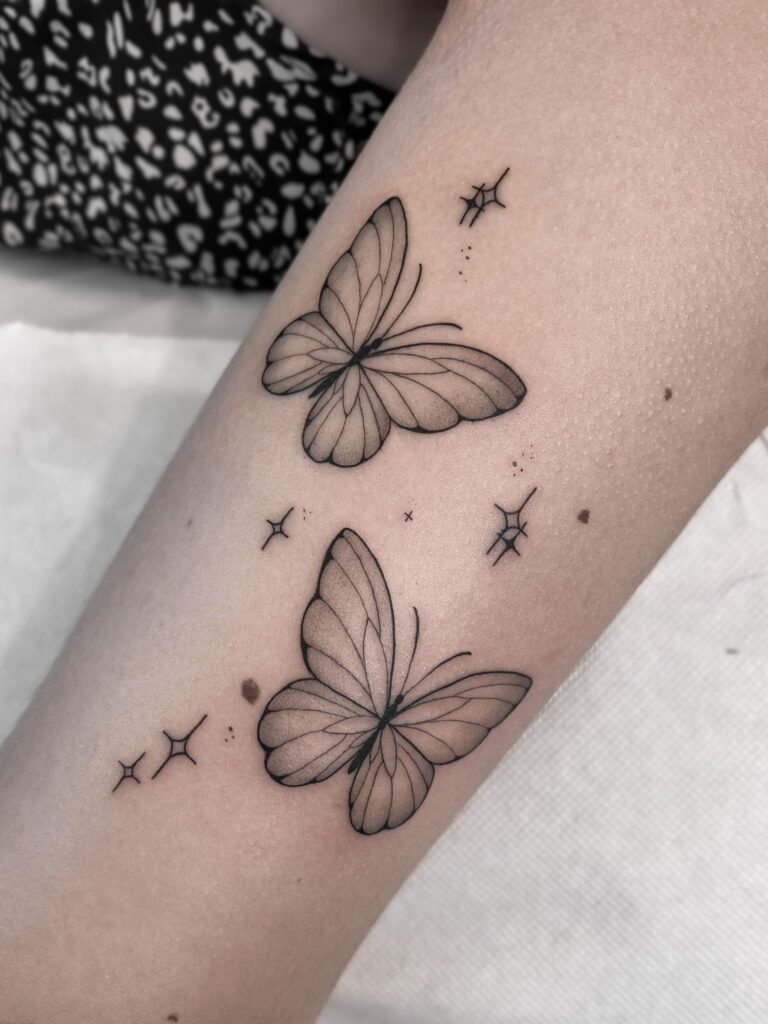 Two fineline butterfly tattoos with sparkles by Meow Ink Alex Lukasiewicz in Den Haag