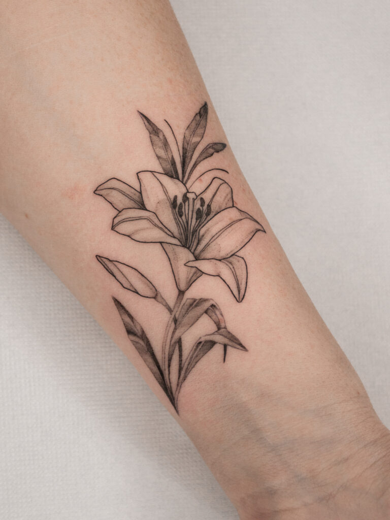Fineline lily flower tattoo on forearm by Meow Ink Alex Lukasiewicz in Den Haag
